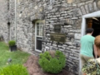 People entering Woodford Reserve with plaque on the building