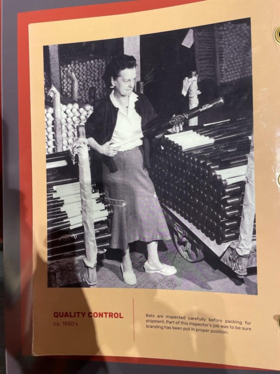 1950s woman inspecting baseball bats for quality control