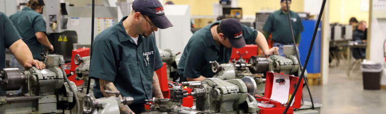 Workers operating machinery in a manufacturing facility.