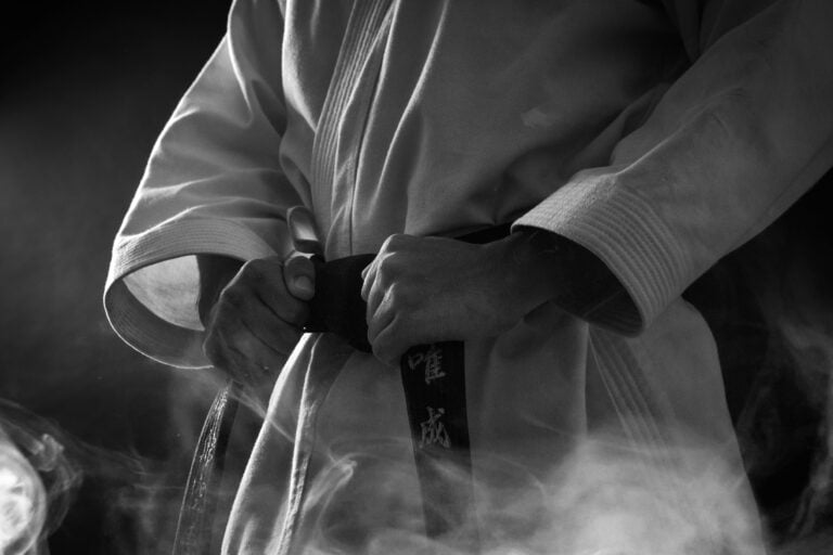 Martial artist tying black belt
